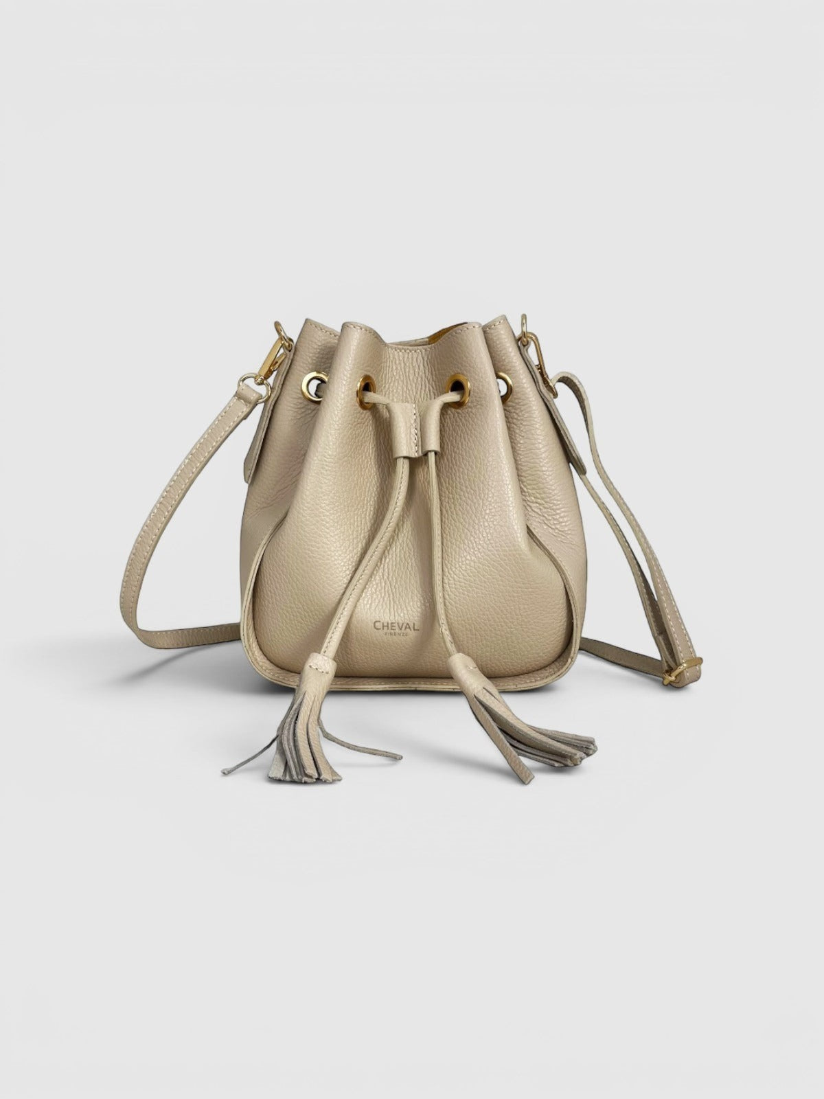 Cheval Firenze Matilde beige leather bucket bag with tassel details and gold hardware. Adjustable strap.