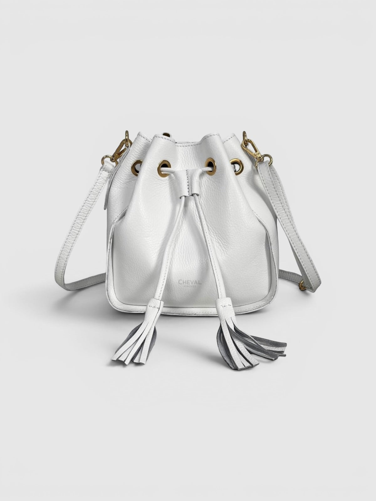 Cheval Firenze white leather bucket bag with tassel details and gold hardware. Adjustable strap.